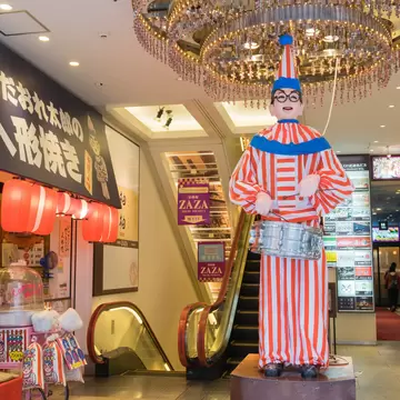 Osaka, Japan - April 27, 2016: The famous Kuidaore Taro Clown in Dotombori Osaka. In front of Cui-daore is a mechanical drum-playing clown, also known as the Kuidaore Ningyo, installed in 1950.  License Type: media  Download Time: 2024-05-22T23:43:18.000Z  User: mvm_lonelyplanet  Is Editorial: Yes  purchase_order:   