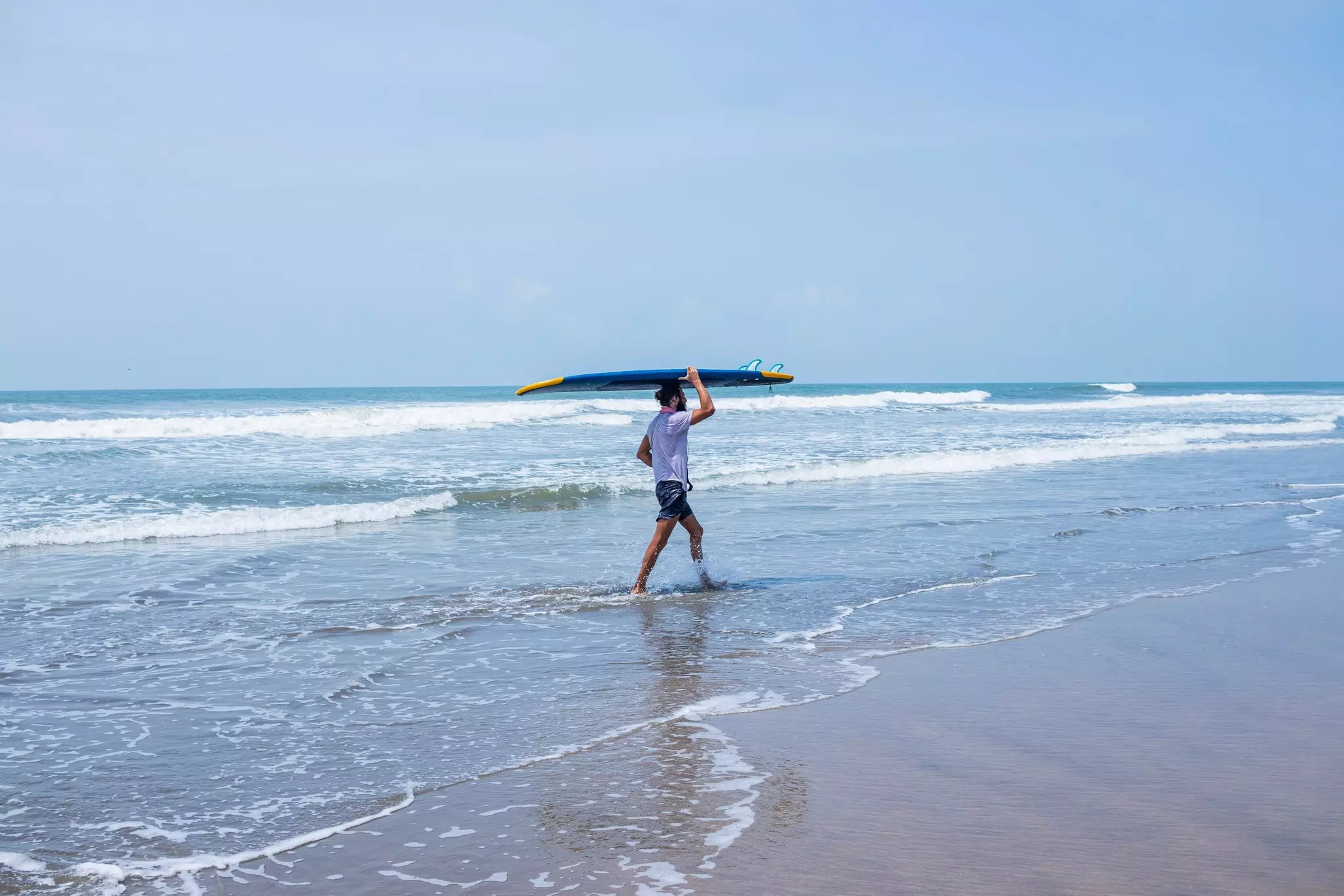 A surfer on the beach in North Goa. Kandarp/Shutterstock