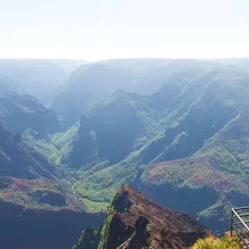 Young man enjoying the beautiful view of Waimea canyon at Kauai island, Hawaii