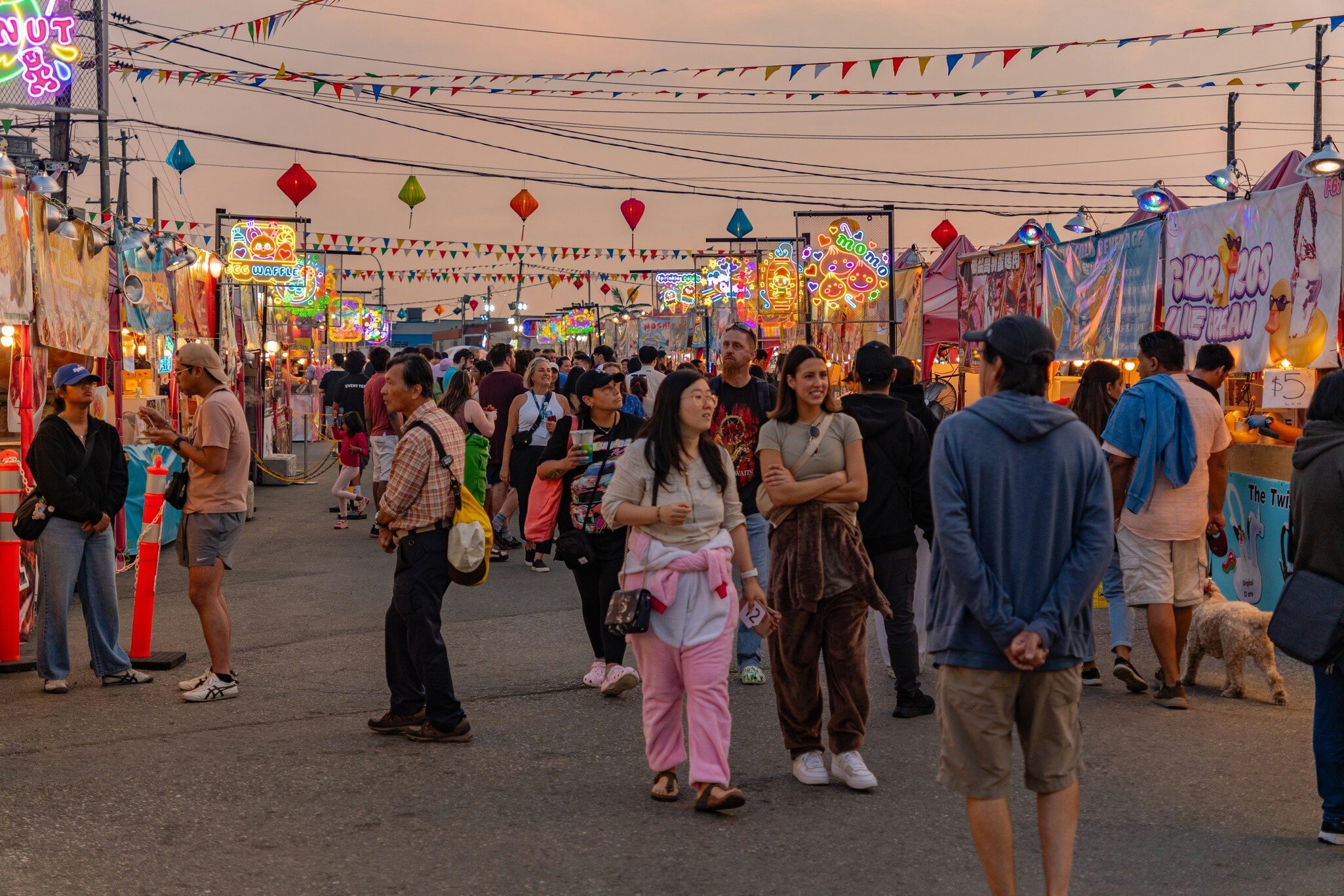 People walking around the local night market in a Chinese neighborhood at twilight in Richmond, Vancouver, BC, Canada.