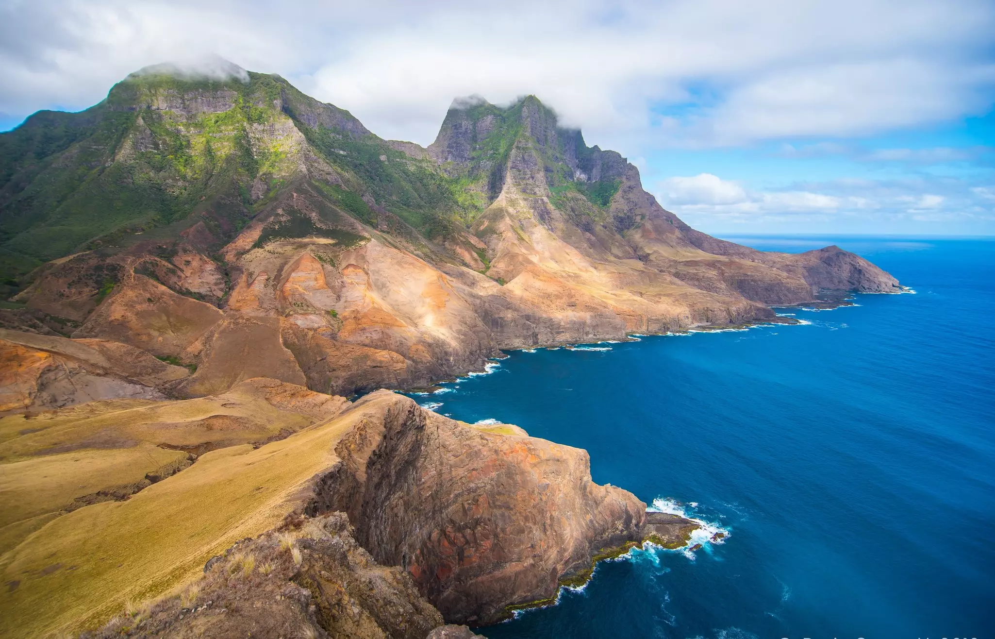 Tall mountains plunging to the sea on an island.