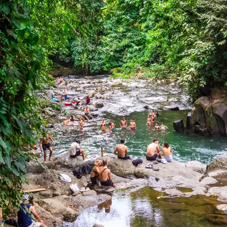 People swimming and bathing on rocks in Rio Fortuna