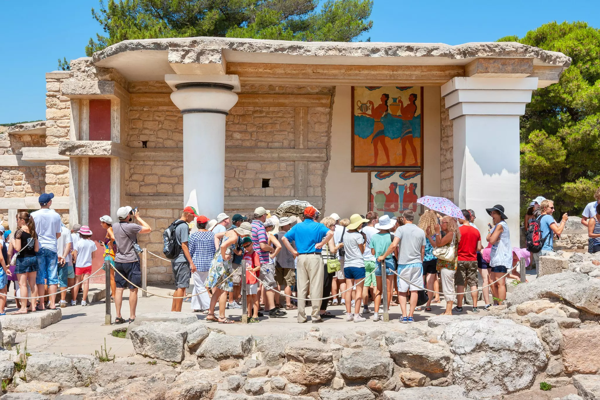 Visitors admire a restored section of the Palace of Knossos in Crete.