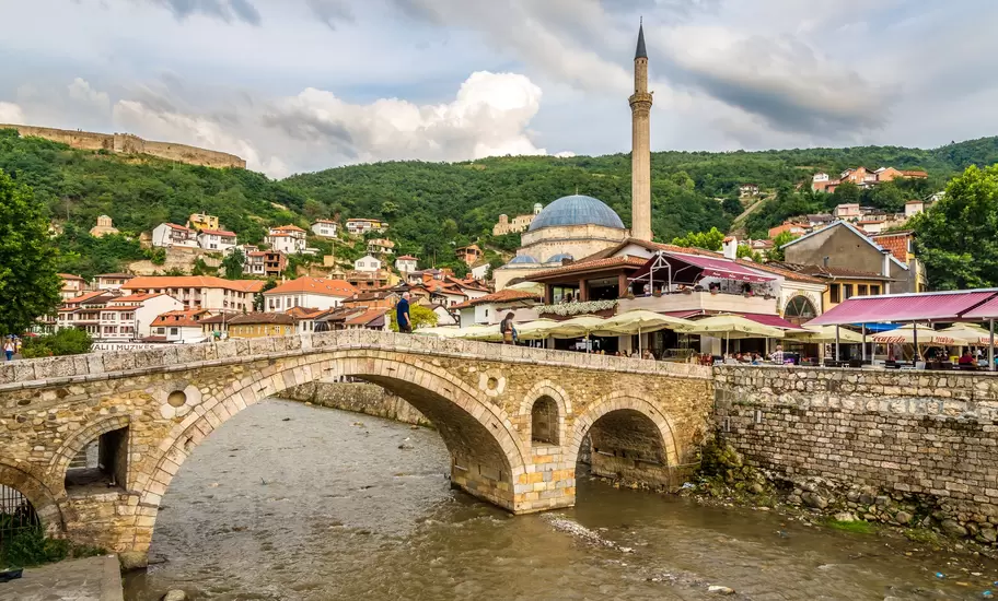 Prizren, Kosovo: an arched Ottoman stone bridge over the Bistrica river, Sinan Pasha Mosque and hilltop fortress behind