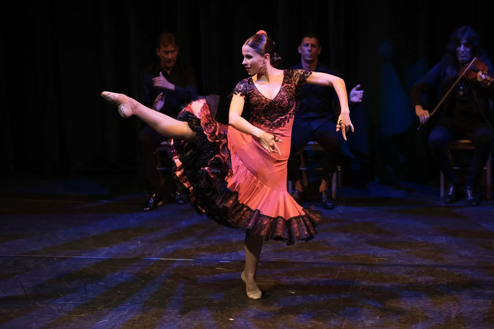 A flamenco dancer performs in Madrid, Spain, with musicians behind. 