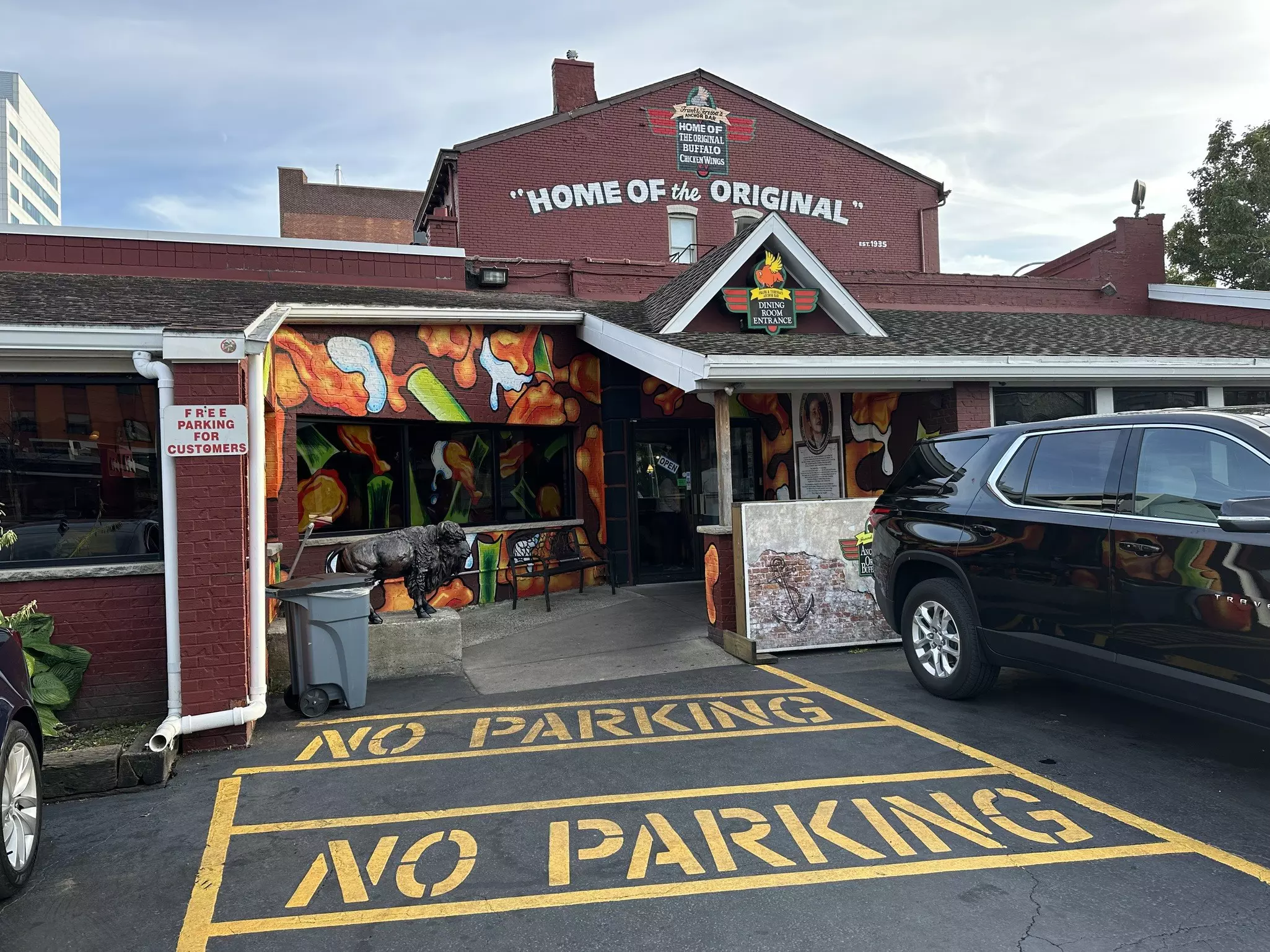 The red building of the original Anchor Bar. The text on the building reads "home of the Original Buffalo Wing" and has a mural of buffalo wings.