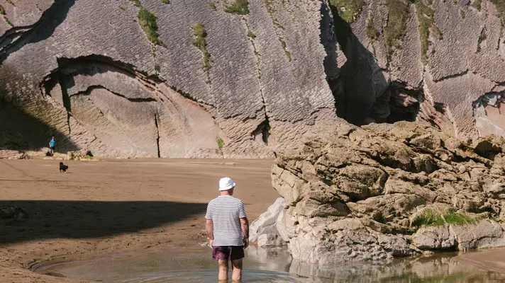 Tide pools in the eroded stone teem with marine life.