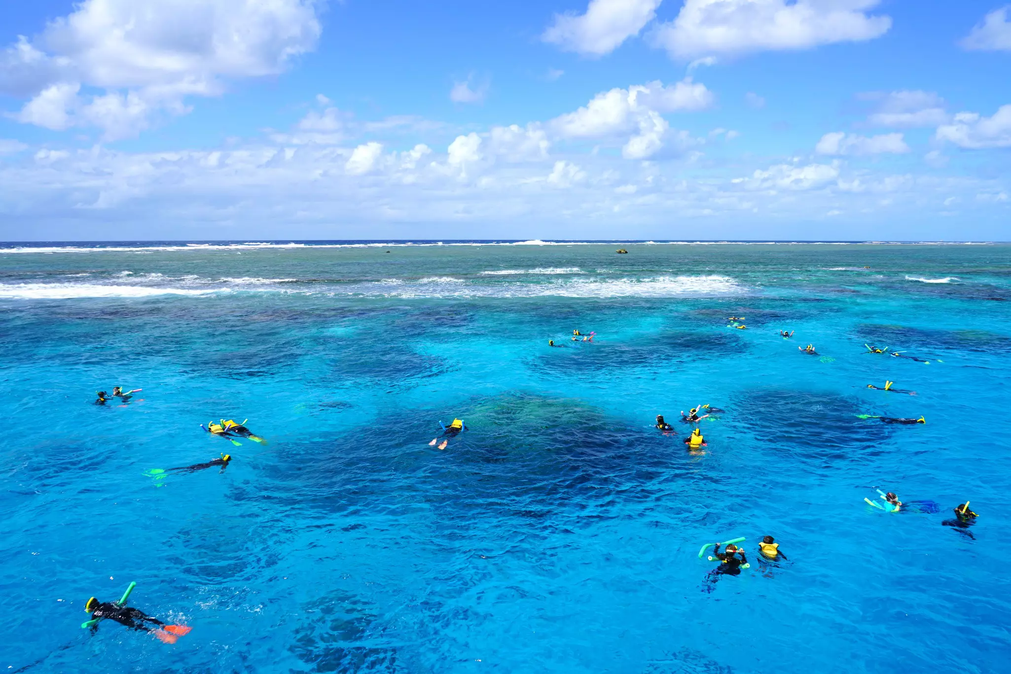 Tourists snorkeling in the Coral Sea on the Great Barrier Reef near the Agincourt Reef in Far North Queensland, Australia.