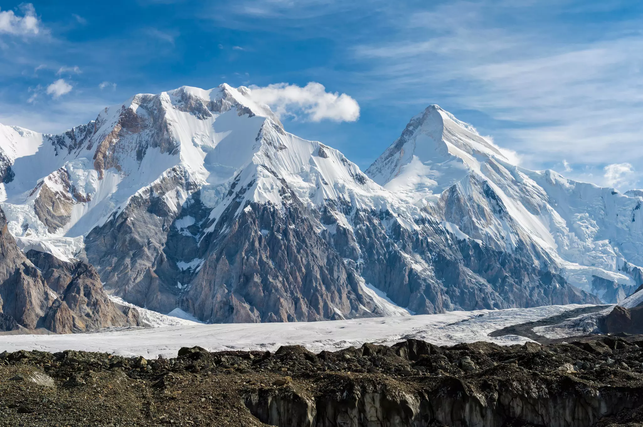 Snow-covered, rocky peaks in the near distance on a sunny day.