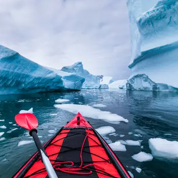 Kayaking in Antarctica between icebergs. NicoElNino / iStock