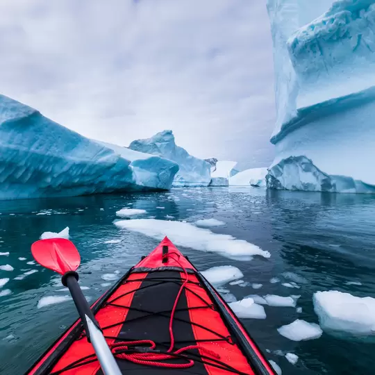 Kayaking in Antarctica between icebergs with inflatable kayak, extreme adventure in Antarctic Peninsula , beautiful pristine landscape, sea water paddling activity