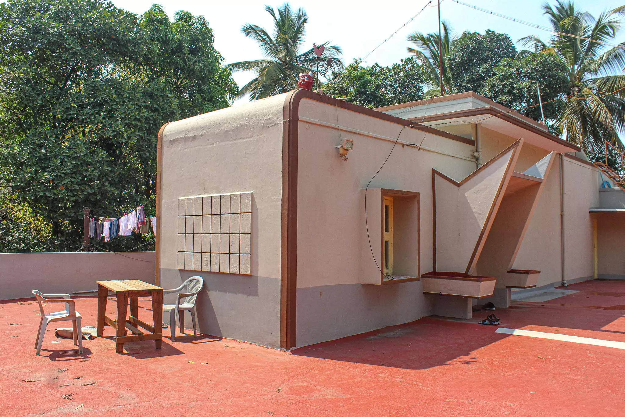 A tan house with brown accents has an angular entryway.
