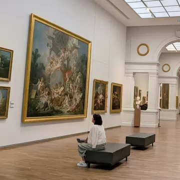 A woman sitting in one of the galleries in the Musée des Beaux Arts, Fine Art Museum, Loire Valley, France.
