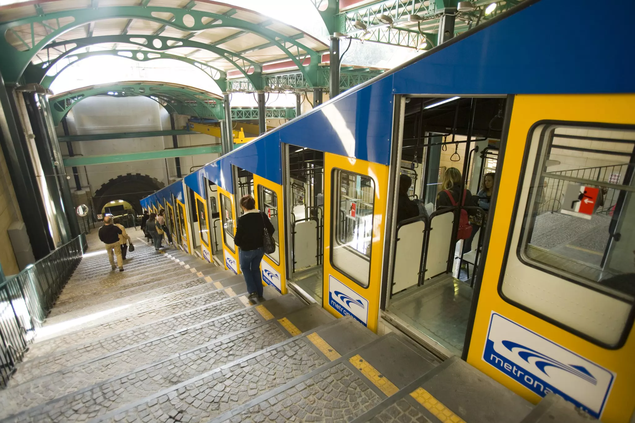 People walking down the stairs next to a funicular railway in Vomero