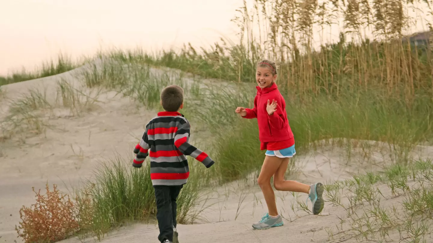 Kids having fun in the dunes on the beach in Sullivan’s Island, near Charleston, South Carolina, The South, USA