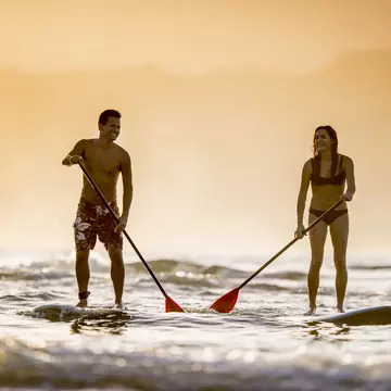 Couple stand up paddleboarding off Kaua'i