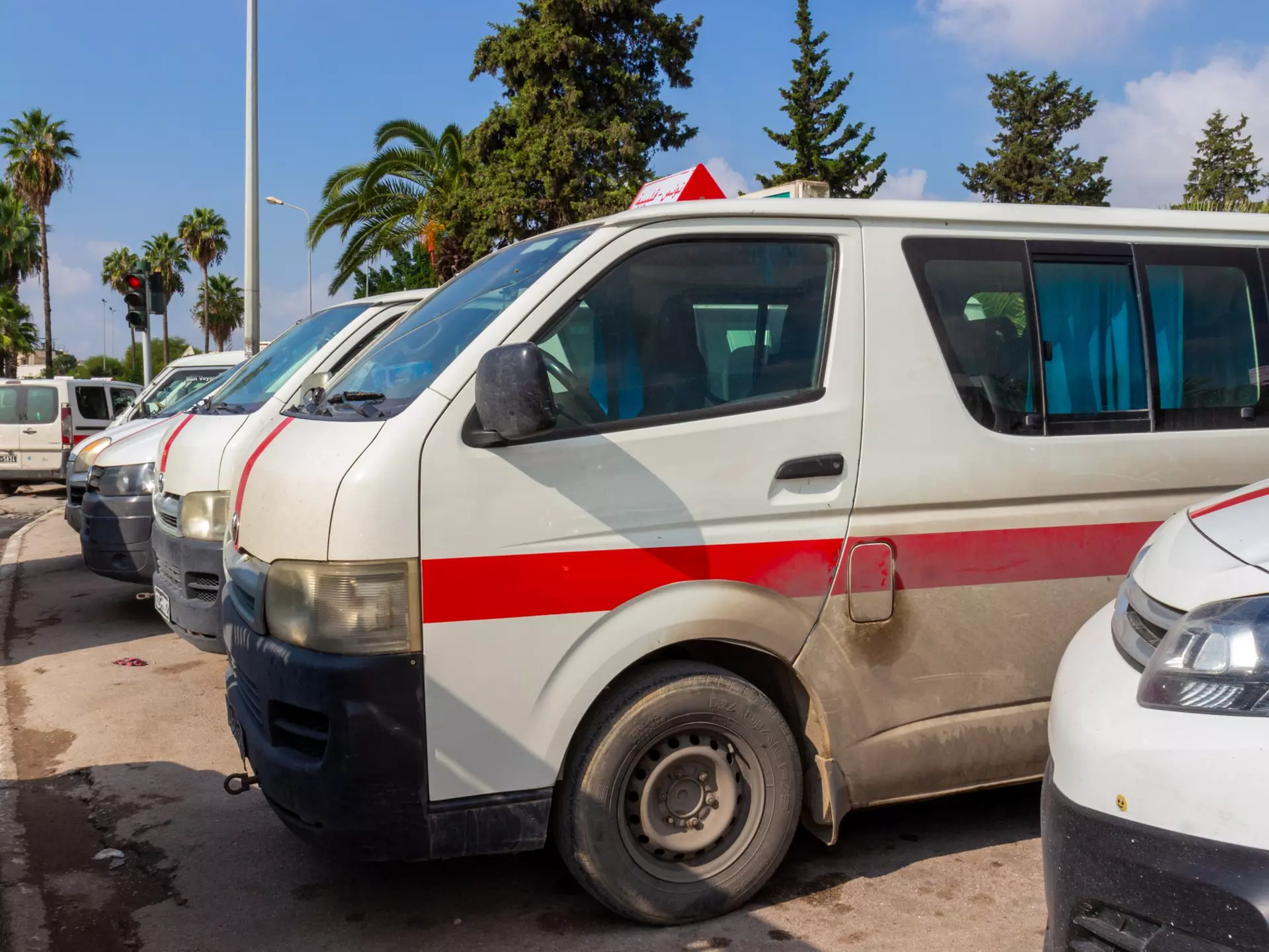 Louages (shared minivans) waiting for passengers in Tunisia.