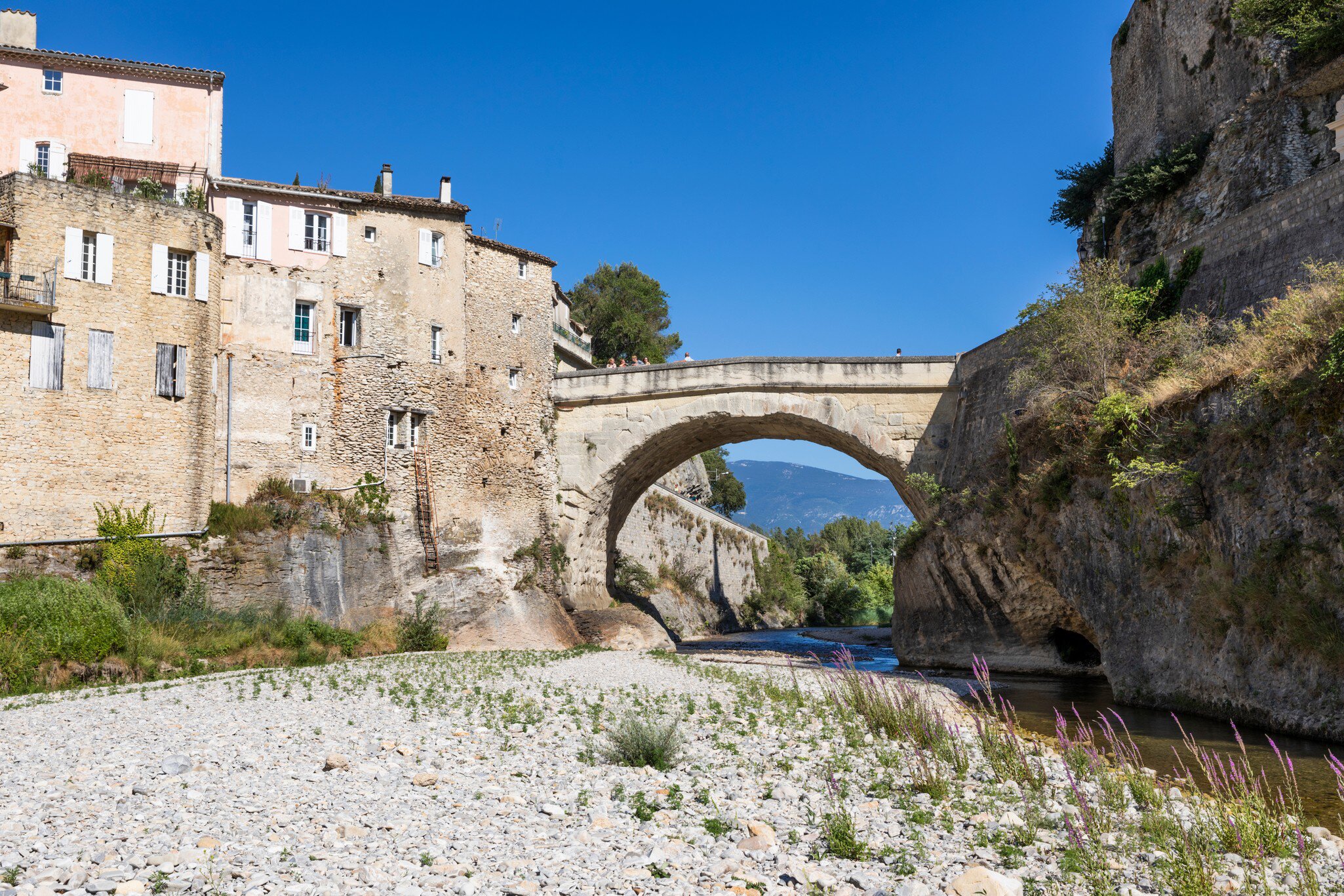Vaison-la-Romaine, Vaucluse department,  Provence-Alpes-Côte d'Azur, France. The Pont Romain over the River Ouveze on sunny summer afternoon.