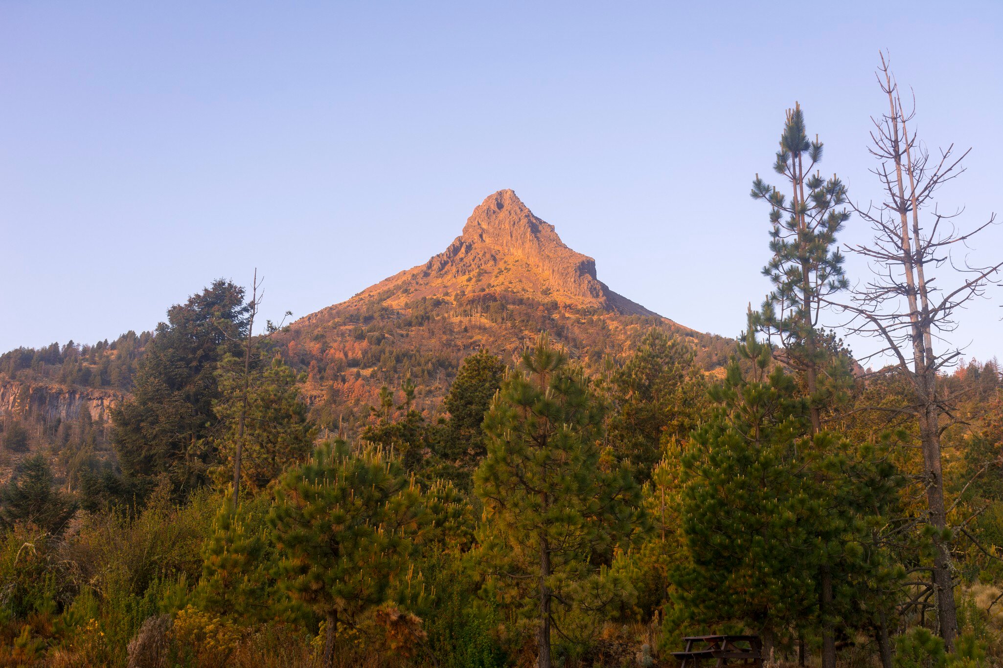 The soft light of the morning illuminating the peak of the nevado de colima's volcano.