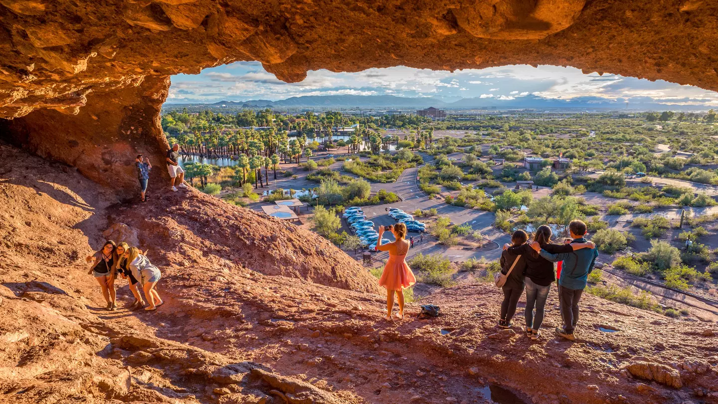 People snap pictures of themselves in the mouth of Hole-in-the-Rock, a tourist attraction in Papago Park, Arizona.