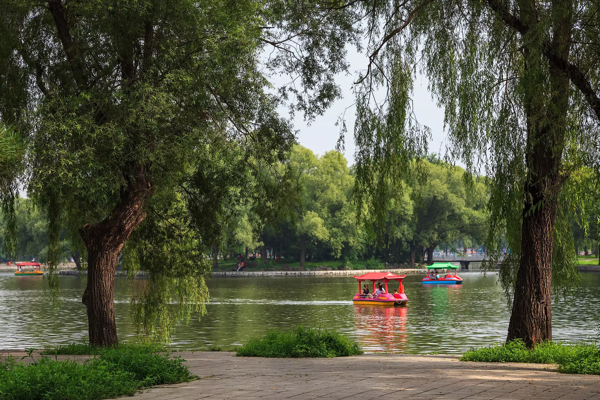 People having a good time on a boats in Beiling Park in summer.