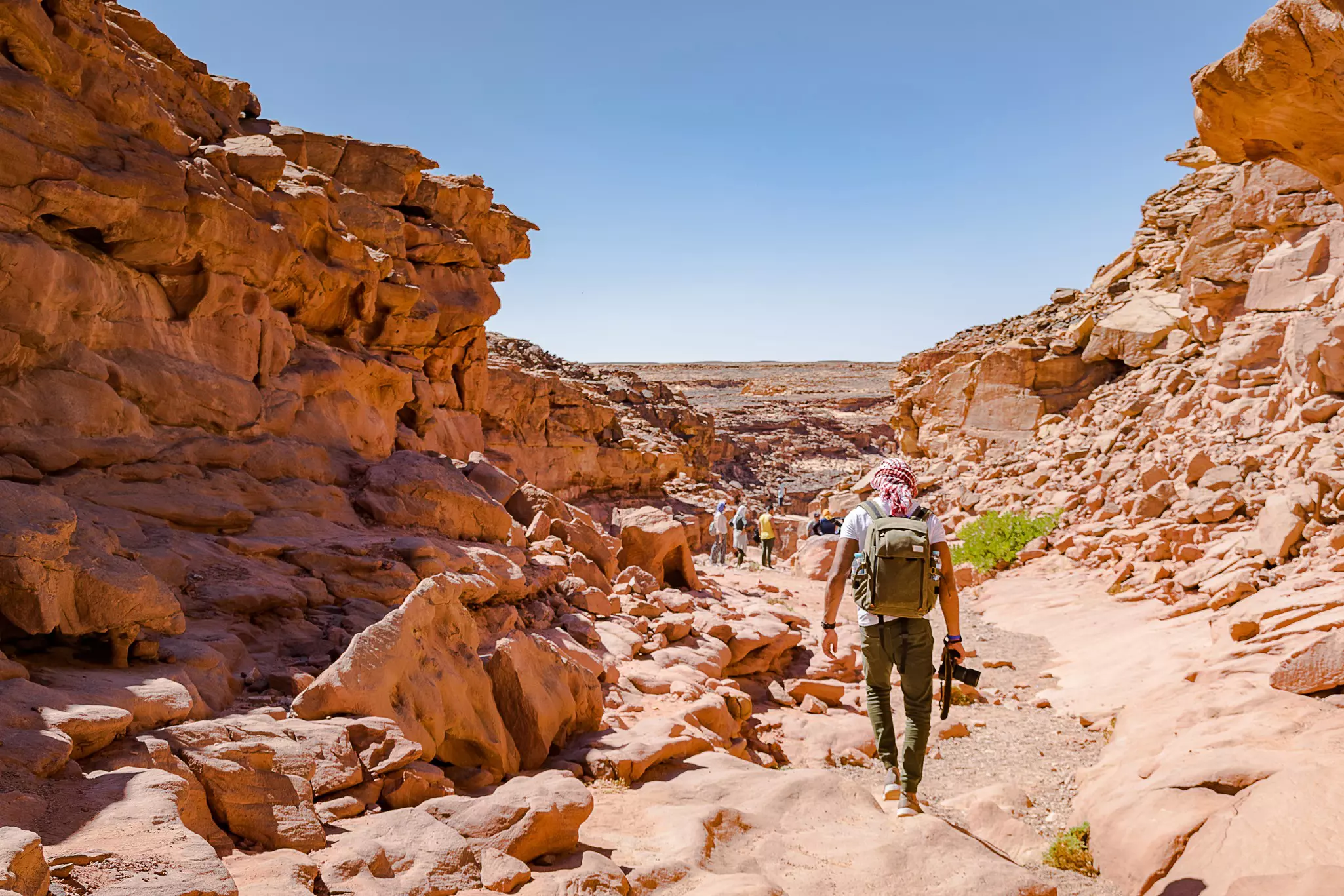 Hikers walk along a colored canyon in Nuweiba, Sinai, Egypt.