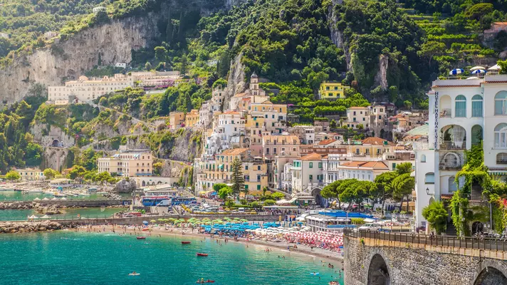 A seaside town climbs up a steep hillside in Italy.