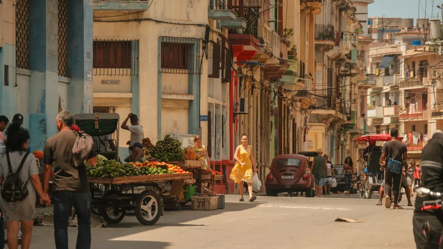 People walking on the streets in Havana, with vendors selling fruits in carts
