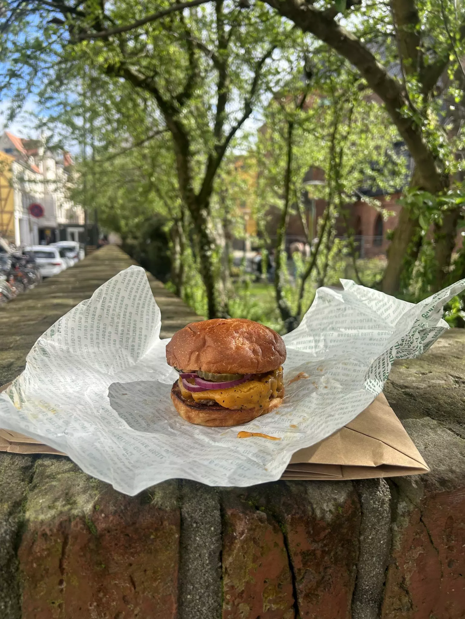 Cheeseburger from Gasoline Grill in Copenhagen sitting on a park wall