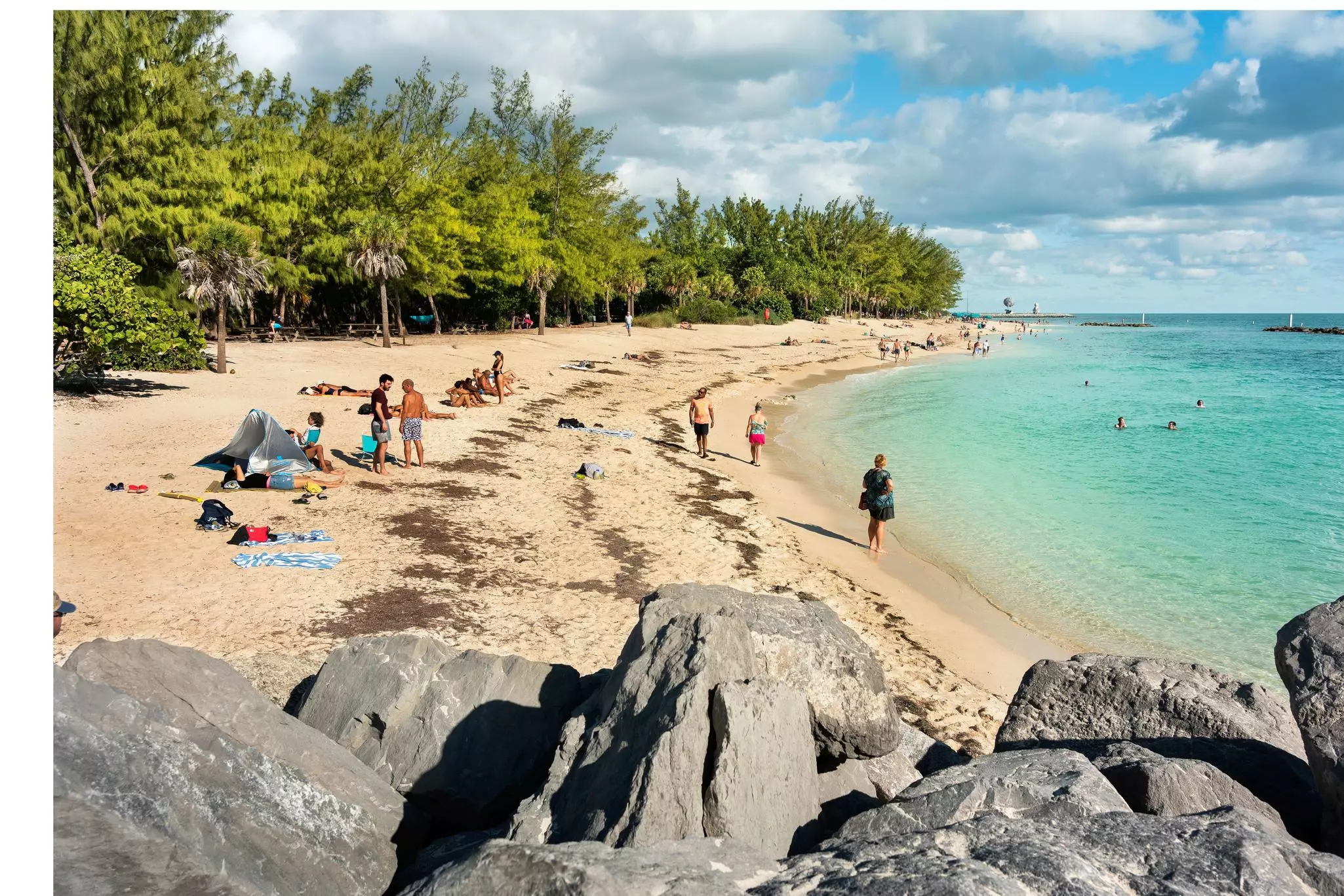 People tan and rest on the sunny beach of Fort Zachary Taylor State Park in tropical Key West Florida USA