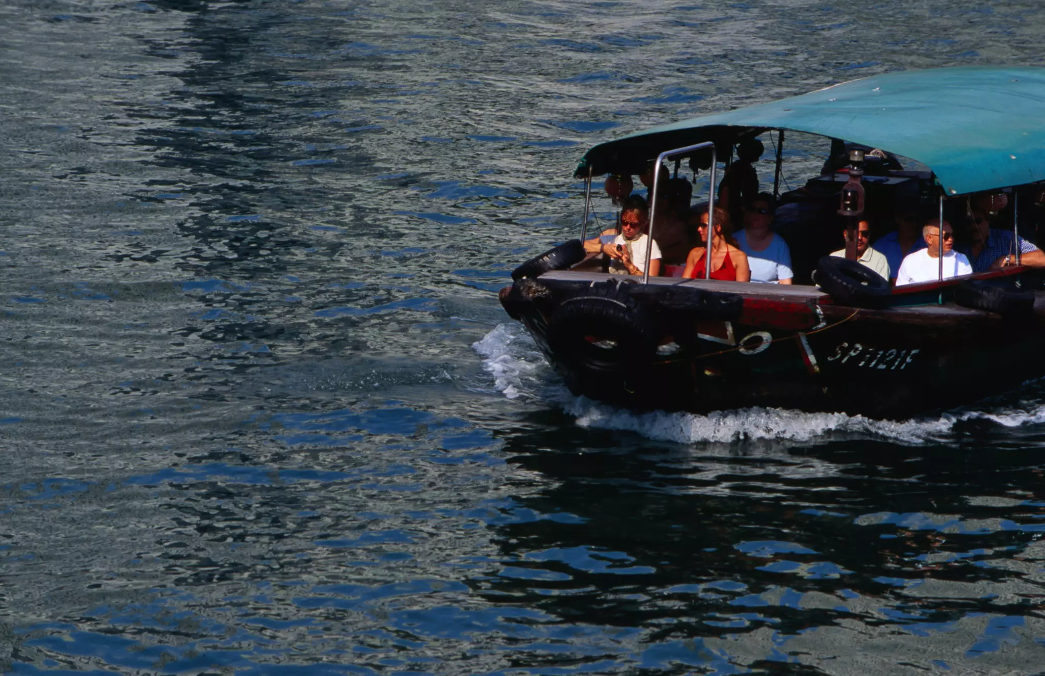 Tourists on a boat tour on the Singapore River. 