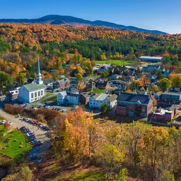 Aerial view of charming small town Stowe in Vermont. Mountains with fall multicolor trees