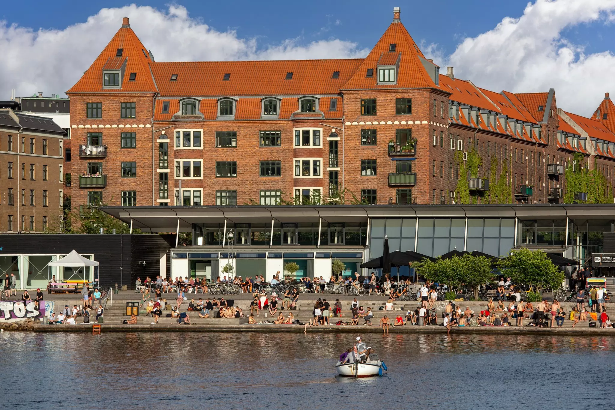 People relaxing on wooden dock of Islands Brygge at Havnestads Havnepark. 