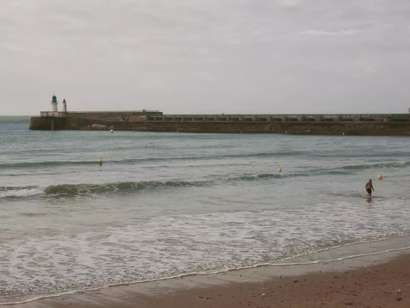 A swimmer walks on the beach in Les Sables d'Olonne.
