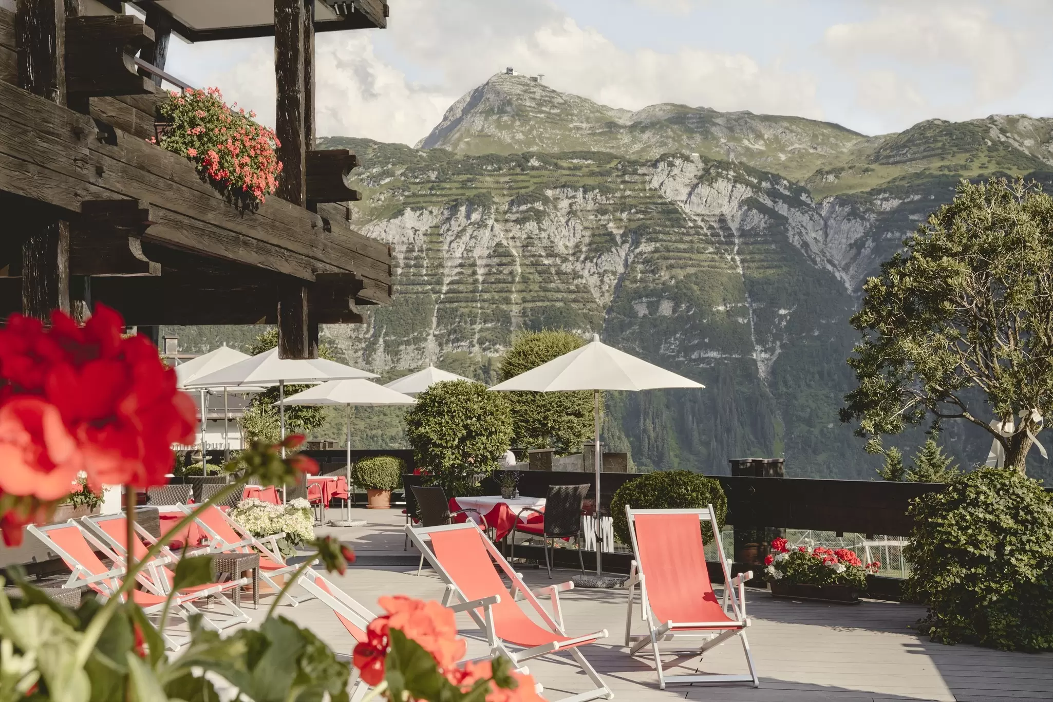 Red loungers on a deck at a chalet in a mountainous region: Burg Hotel Oberlech, Austria