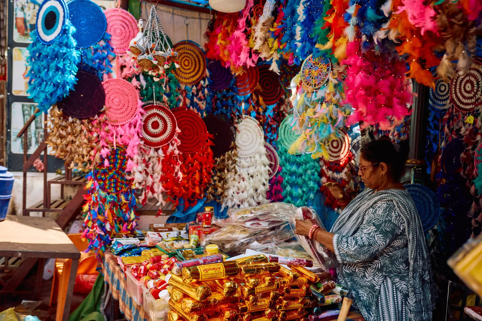A vendor at a shop with a colorful display.