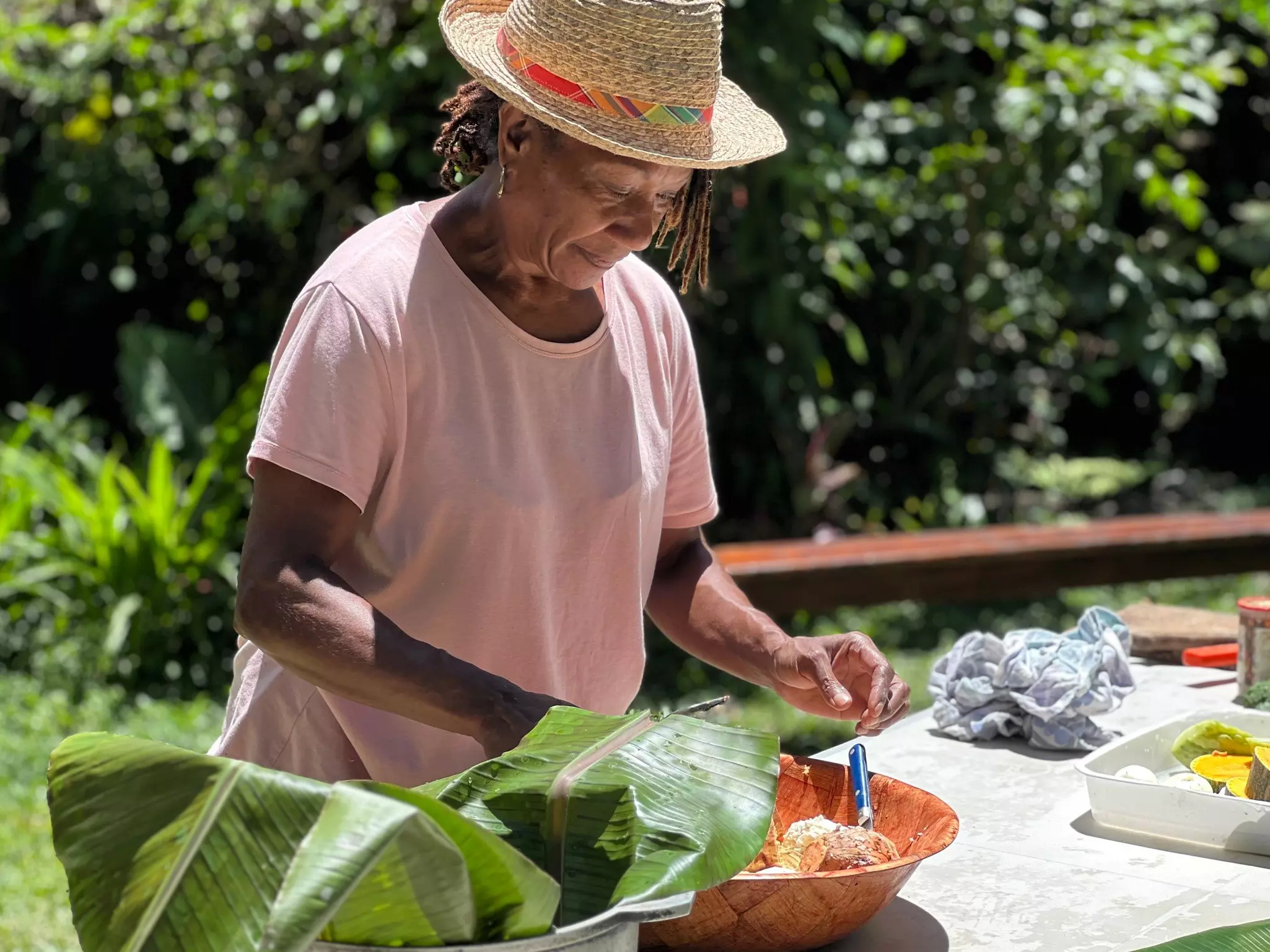 A woman prepares food at an outside table. 