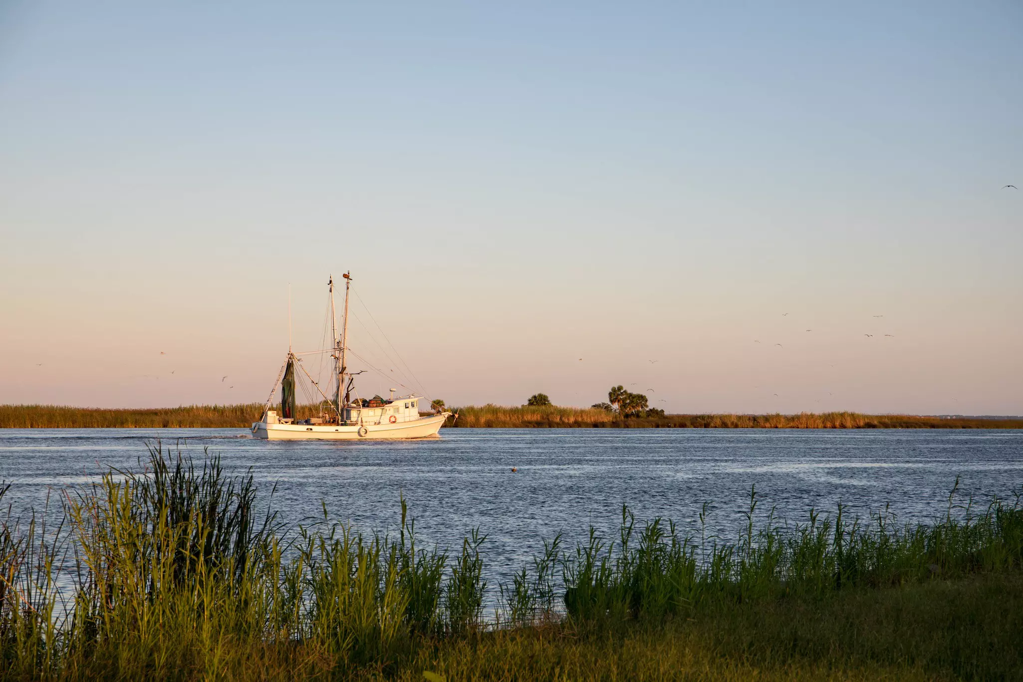 A fishing boat in dusky light on a waterway in Florida.