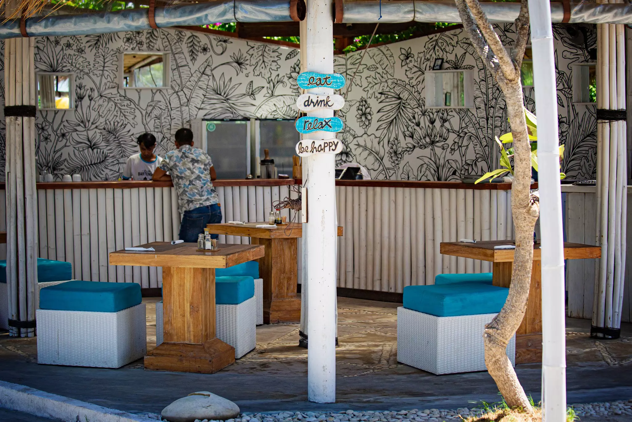 Cozy beach lounge cafe with wooden furniture and bar on Gili Air, Bali.