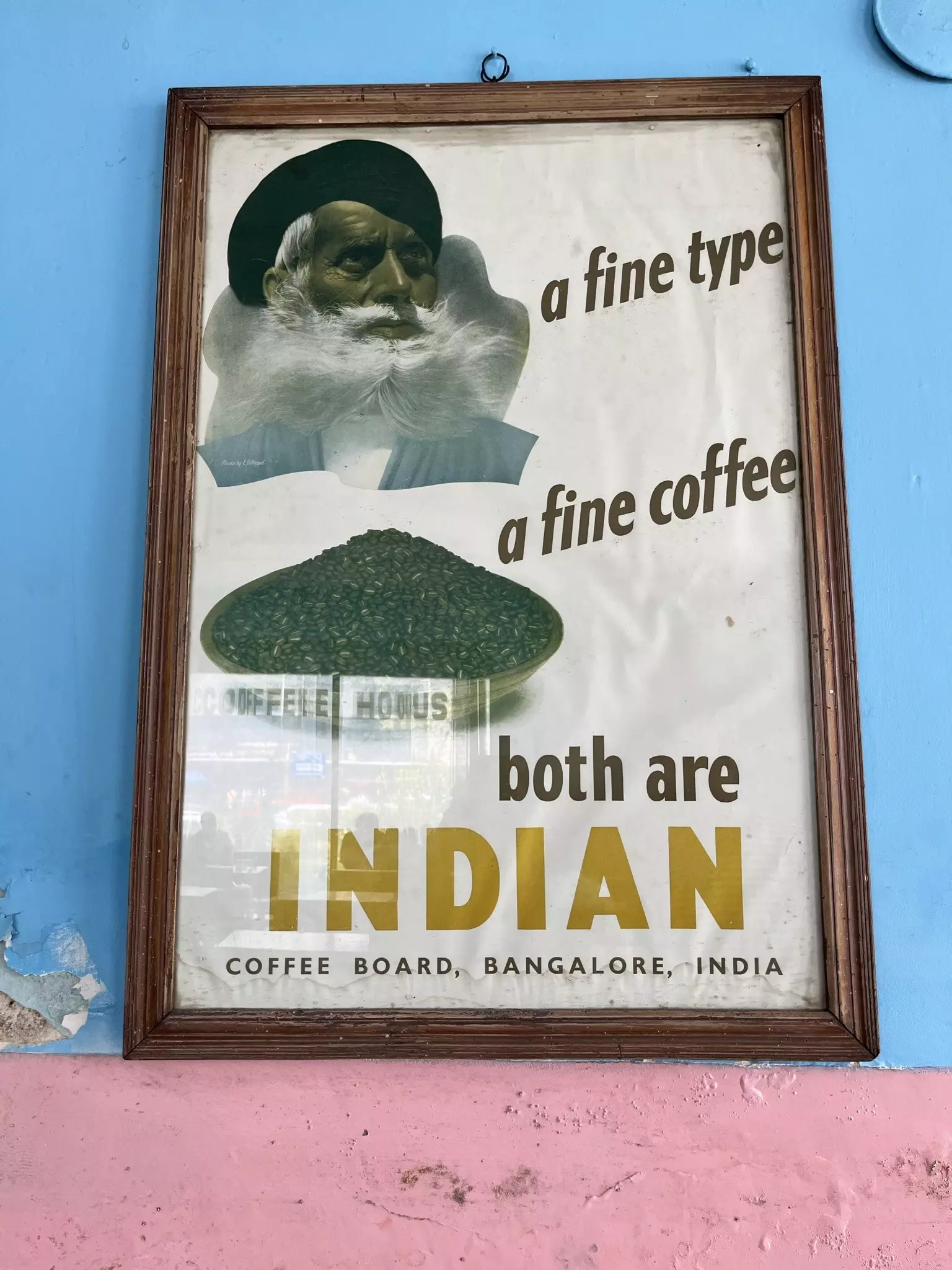 A framed poster advertising Indian coffee mounted on the walls of a coffee house
