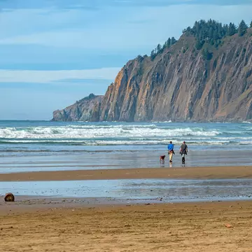 Dog walkers on Manzanita beach, Oregon. Rigucci/Shutterstock