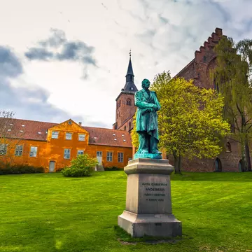 A statue of Hans Christian Andersen in a field behind the Domkirke, Odense, Denmark. RPBaiao/Shutterstock