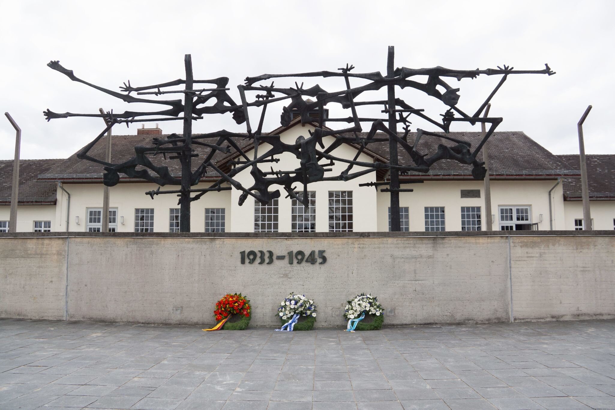 Exterior of camp facilities with memorial sculpture and wall,  at Dachau Concentration Camp, Munich, Germany.