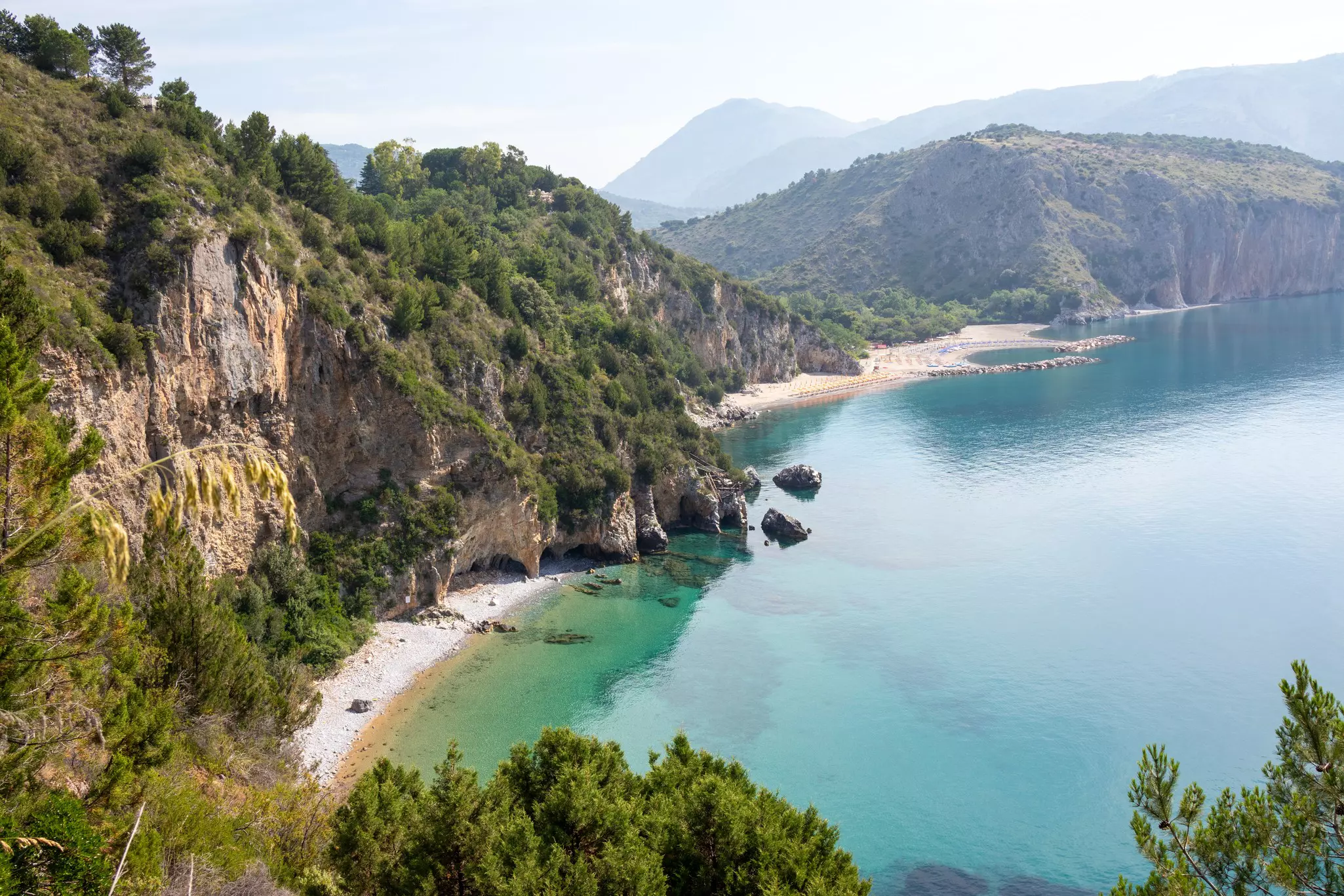 Mountainous landscape with white sandy beach and blue sea