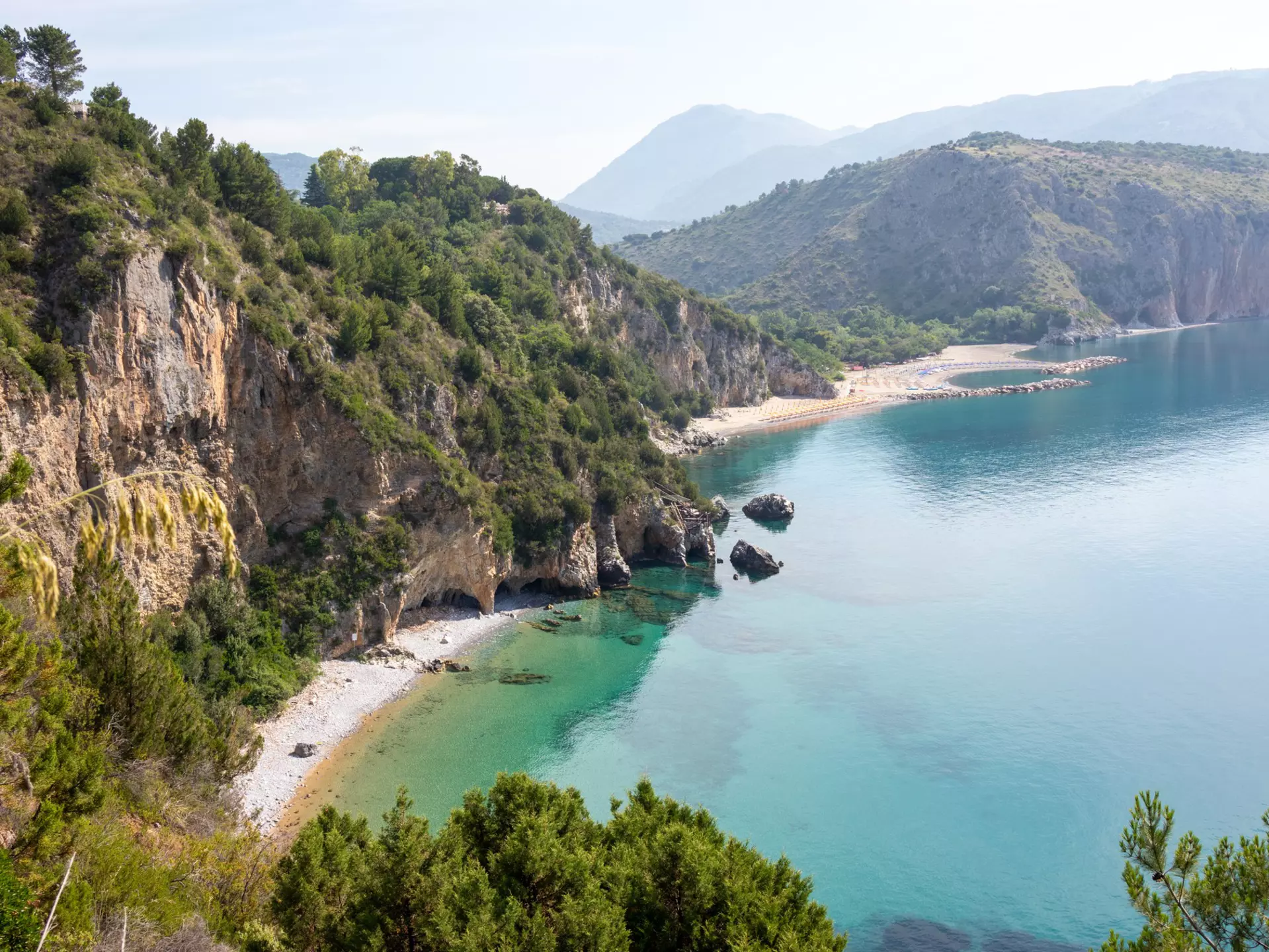 Mountainous landscape with white sandy beach and blue sea