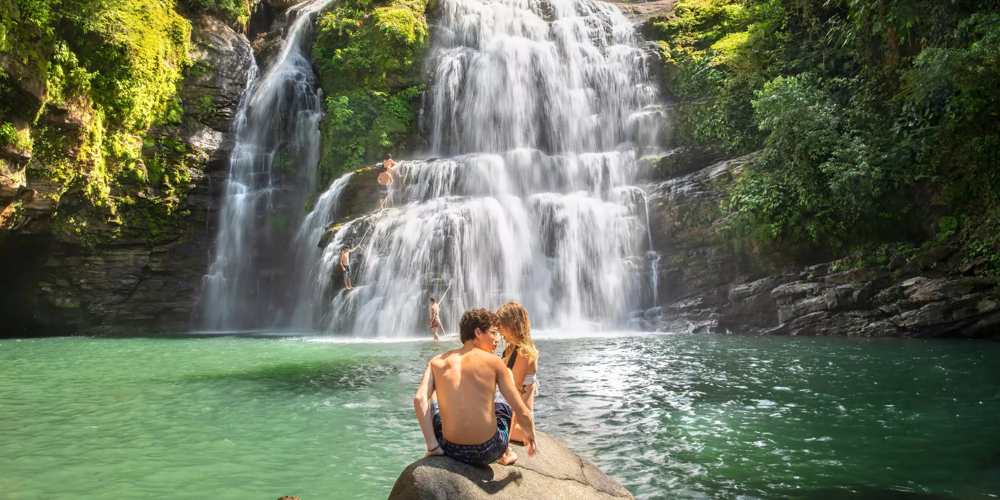 MANUEL ANTONIO NATIONAL PARK  COSTA RICA-JANUARY 07, 2020: Young people enjoy swimming in a waterfall in the jungle