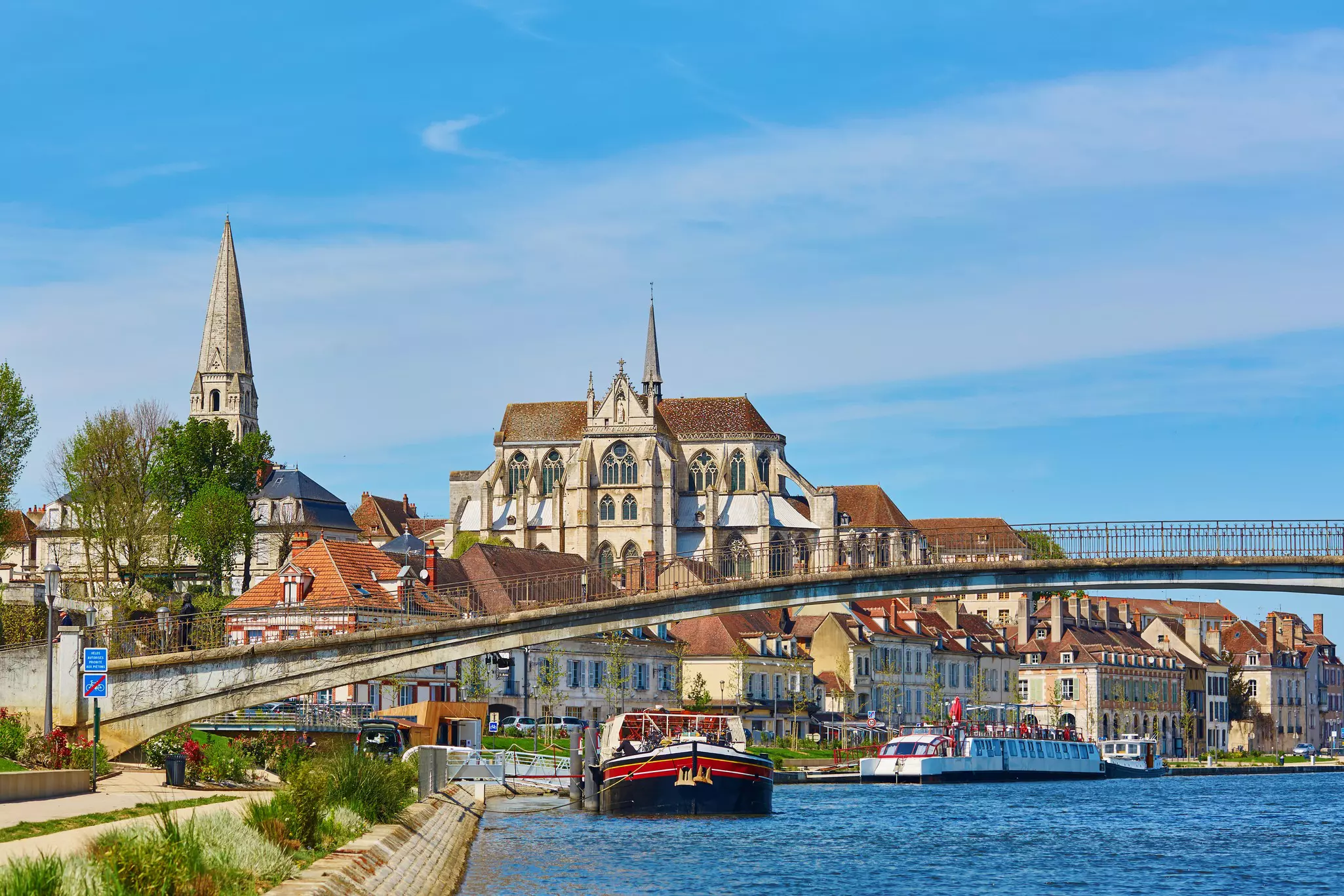 A large church stands in the center of a cluster of buildings beside a river.