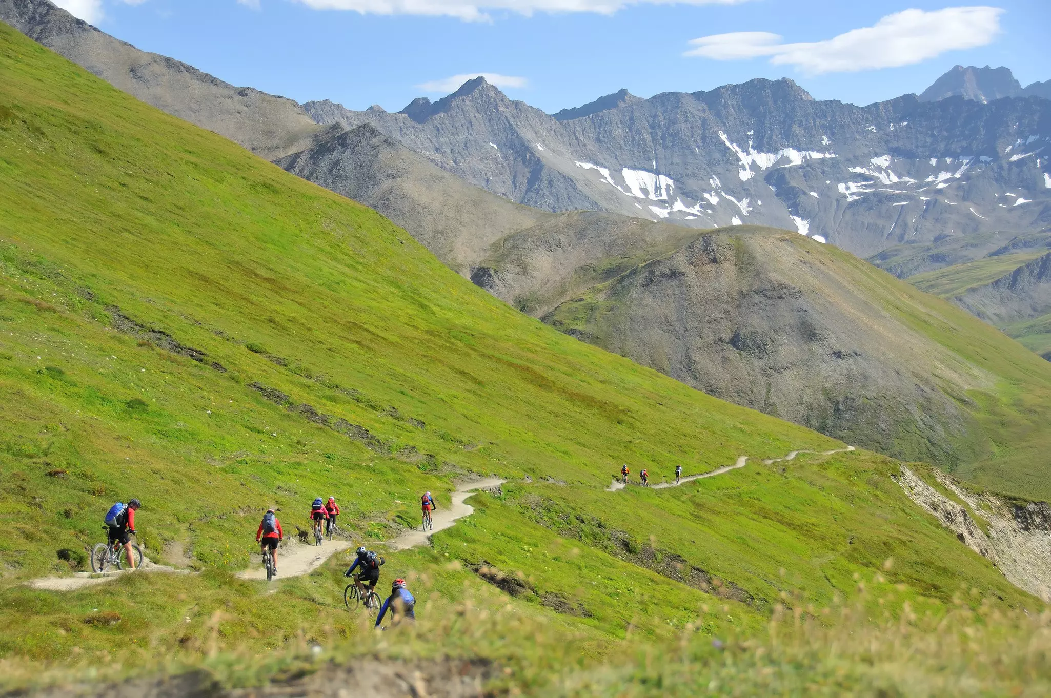 A group of mountain bikers descend down a narrow trail near Mont Blanc, Alps, Europe