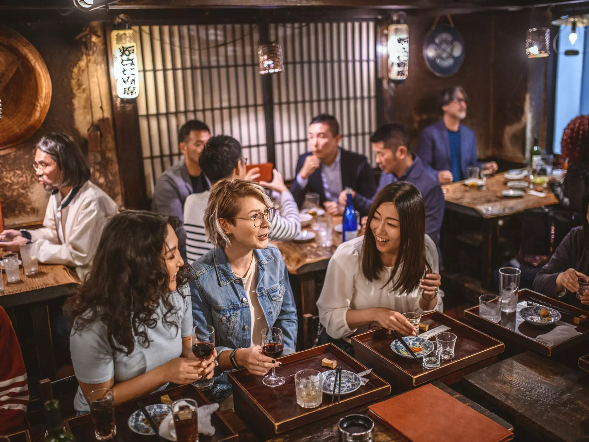 Wide angle view of Mongolian, Japanese, and Caucasian women sitting at sushi bar and other patrons in Tokyo izakaya.
1176105697