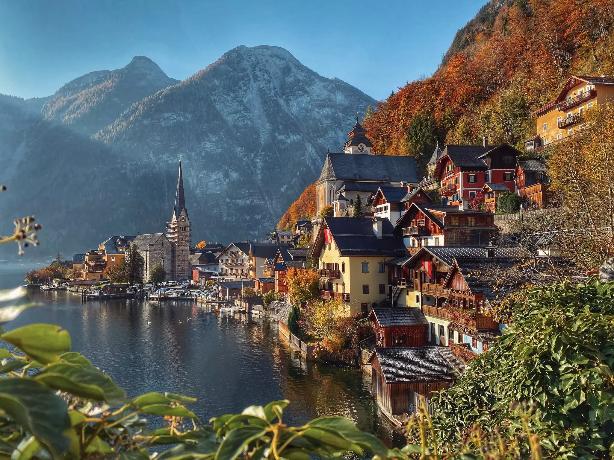 Historic Hallstat sits on the edge of a flat lake, with mountains in the background, Austria